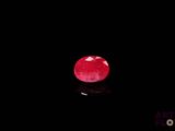 a close up of a red stone on a black surface