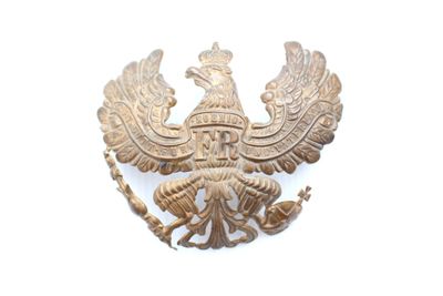 une broche de couleur dorée sur laquelle figure un oiseau sur sa tête