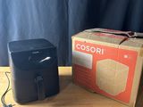 une photo représentant une boîte et une imprimante noire posées sur une table en bois