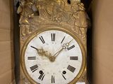 a gold clock in a cardboard box that is open