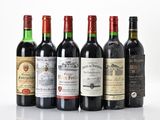 several bottles of wine are lined up on a white surface