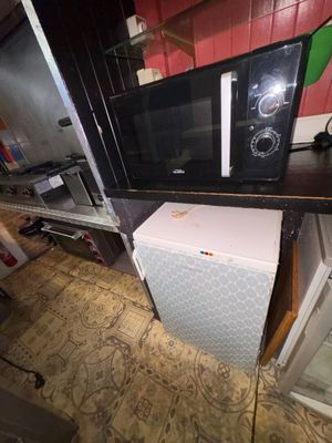 a microwave sitting on top of a refrigerator in a kitchen