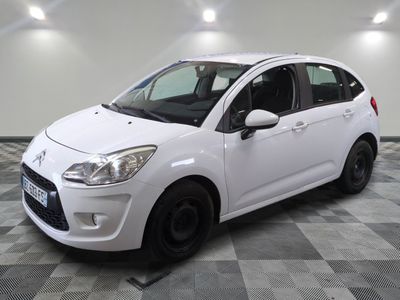 la petite voiture blanche est garée sur un sol en damier