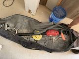 un homme debout à côté d'un sac contenant des outils