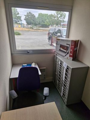 un bureau avec un ordinateur et une imprimante dans un coin