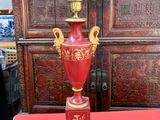 une table rouge sur laquelle est posée une lampe