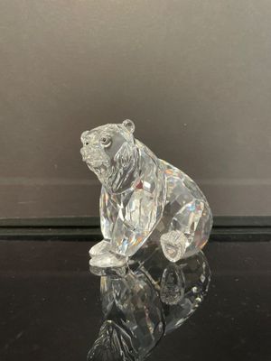 figurine en cristal représentant un ours assis sur une surface noire