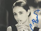 une vieille photo d'une femme assise à une table, une cigarette aux lèvres