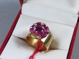 a gold ring with a pink stone in it