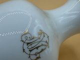 a white vase with a gold design on it