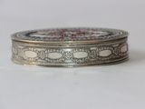a silver box with a design on it on a white surface