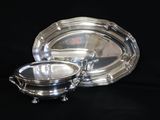 deux assiettes plaquées argent et un bol sur fond noir