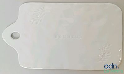 une photo d'une planche à découper blanche sur laquelle figure un nom