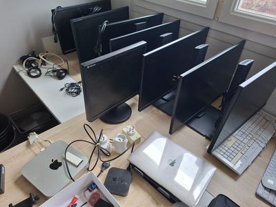 beaucoup d'ordinateurs posés sur un bureau, avec plein de câbles