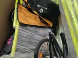 a box with a bike and a bag in it