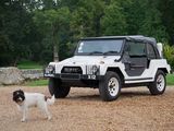 a dog standing next to a white jeep parked in a driveway