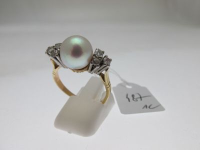 un gros plan d'une bague ornée d'une perle et de diamants