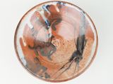 a brown and black bowl sitting on a white surface