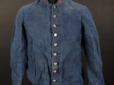 a blue jean jacket on a mannequin stand against a black background