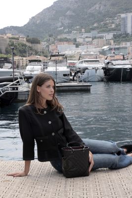 une femme assise sur le quai au bord de l'eau