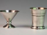 two silver cups sitting next to each other on a table