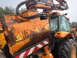 a tractor that is parked in a lot next to other tractors