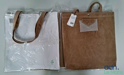 un sac marron et un sac blanc posés sur une table
