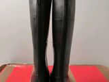 a pair of black boots sitting on top of a cardboard box