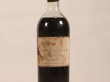 an old bottle of liquor sitting on top of a white surface