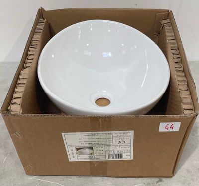 un bol blanc dans une boîte en carton posée par terre