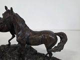 a statue of a horse that is standing on a rock