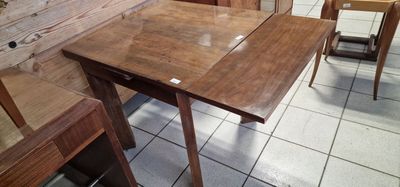 a table and chairs in a room with a wooden wall