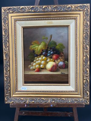 un tableau représentant des raisins et des pommes posés sur une table, avec un chevalet en bois