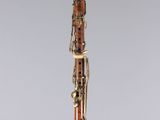 a close up of a wooden clarinet on a clear surface