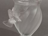 a glass vase with a flower on it on a table