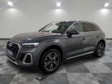 une Audi QX grise garée sur un sol en carrelage à damier