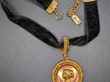 a close up of a necklace with a pearl on it