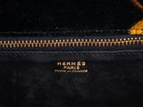 a close up of a black purse with a gold zipper