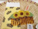 a yellow comb with yellow flowers on it sitting on a basket