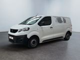 La petite camionnette blanche est garée dans une grande pièce.
