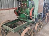 an old green tractor with two wheels in a building