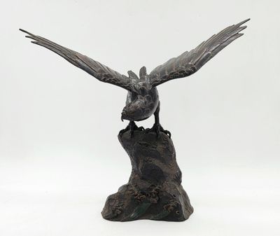 statue représentant un oiseau perché sur une souche d'arbre, sur fond blanc