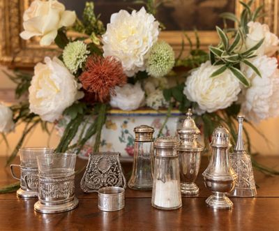 une table sur laquelle se trouvent un vase de fleurs et de l'argenterie