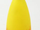 un vase jaune et rouge posé sur une surface blanche