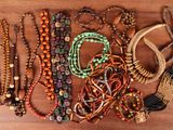 many different colored beads and bracelets laid out on a table