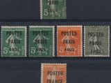 four different postages of different colors and sizes on a black background