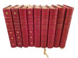 six livres rouges empilés les uns sur les autres sur une surface blanche