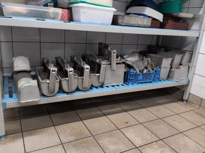 many pots and pans on the shelf in the kitchen