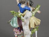 two figurines of a couple sitting on a tree branch