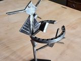 une sculpture métallique représentant un oiseau, posée sur une table